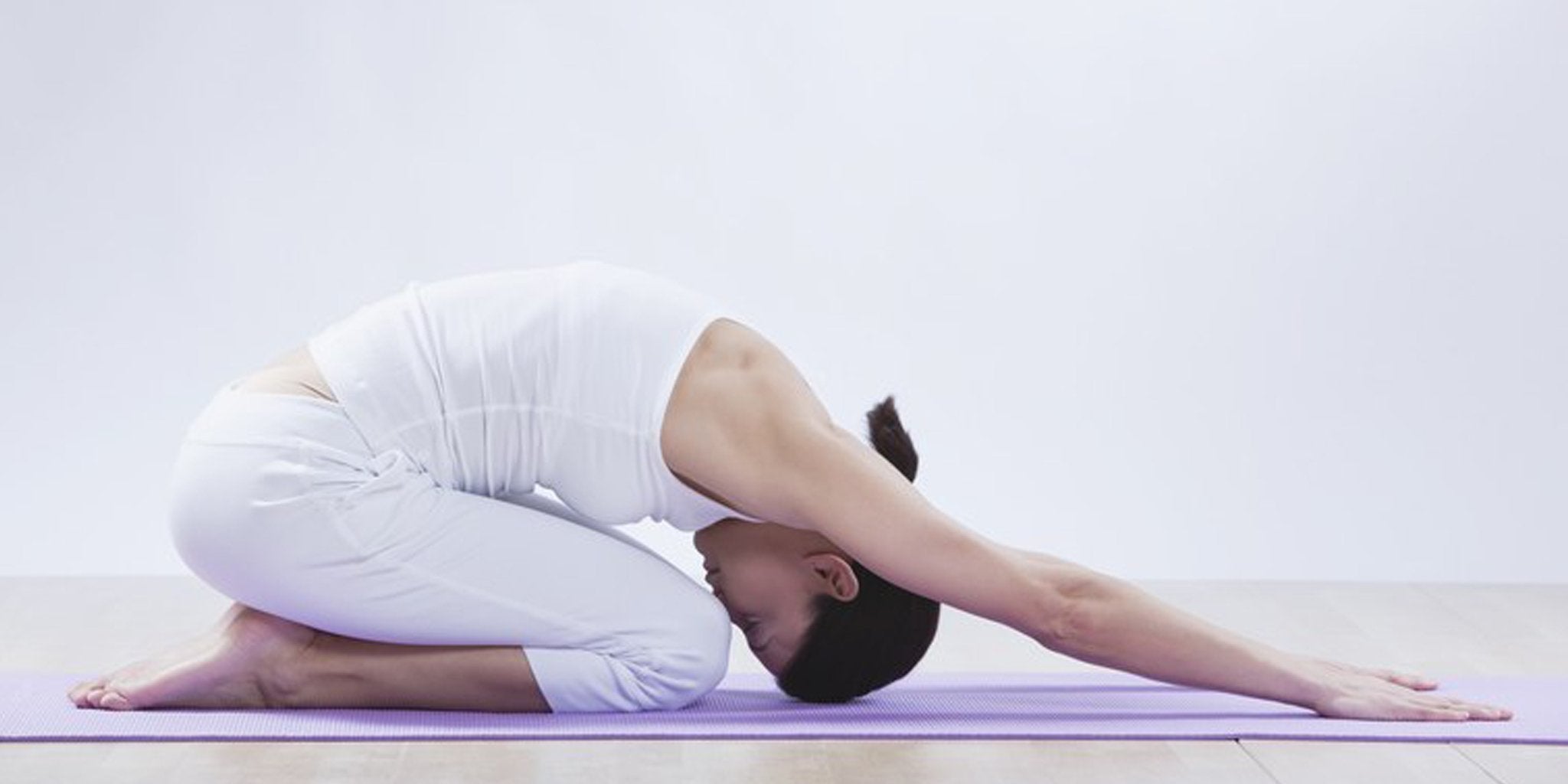 Woman in printed yoga leggings doing a yoga pose at studio