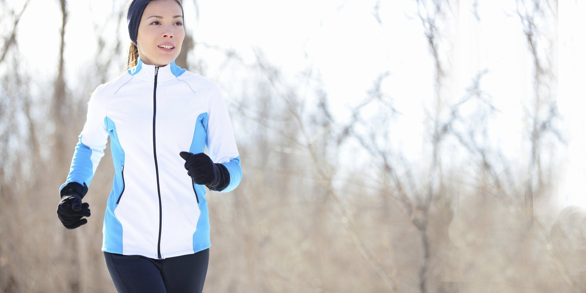 Woman in winter activewear runs in snow: jacket, leggings, and hat