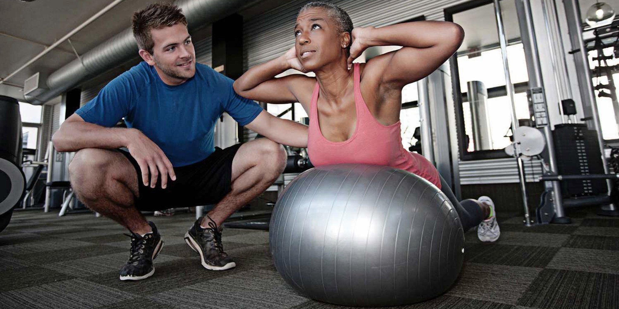 Woman demonstrating the ball pike to plank exercise using a gym ball