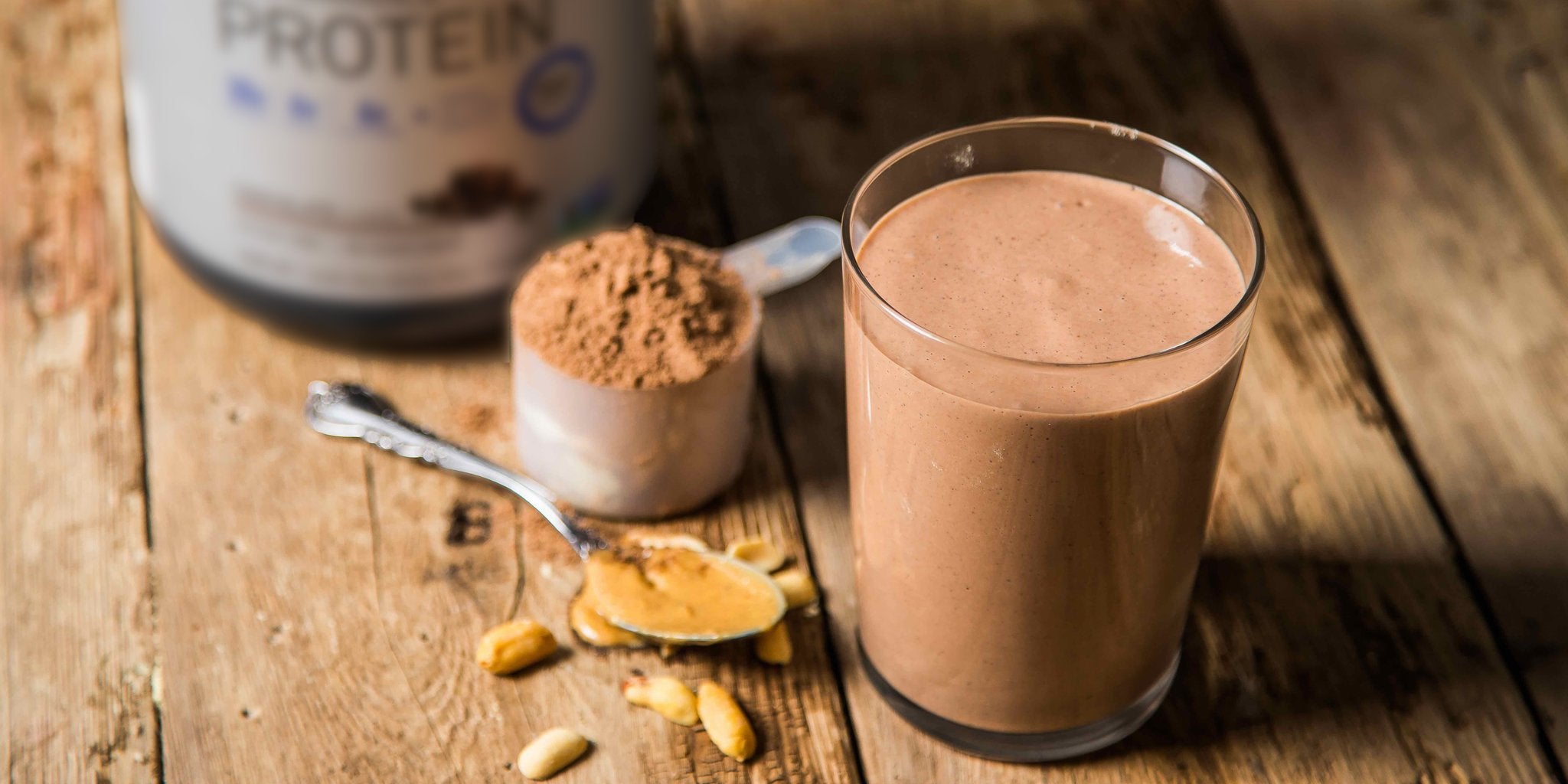 Woman in activewear making a protein shake at her home gym