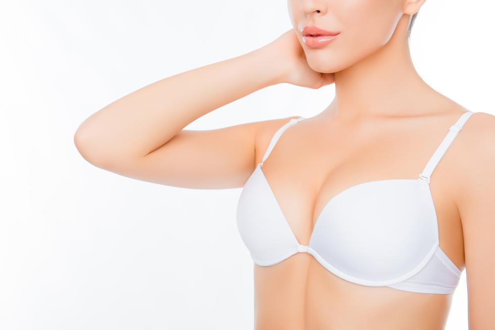 Illustration of a woman examining her breasts, explaining causes of sagging