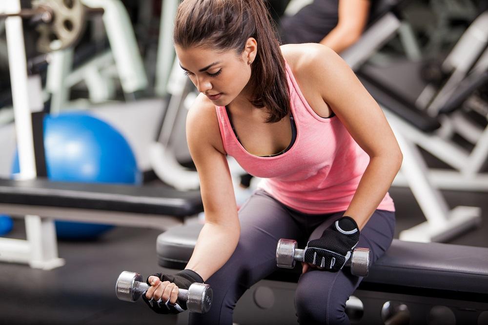 Woman lifting weights in stylish printed leggings, strength training for women