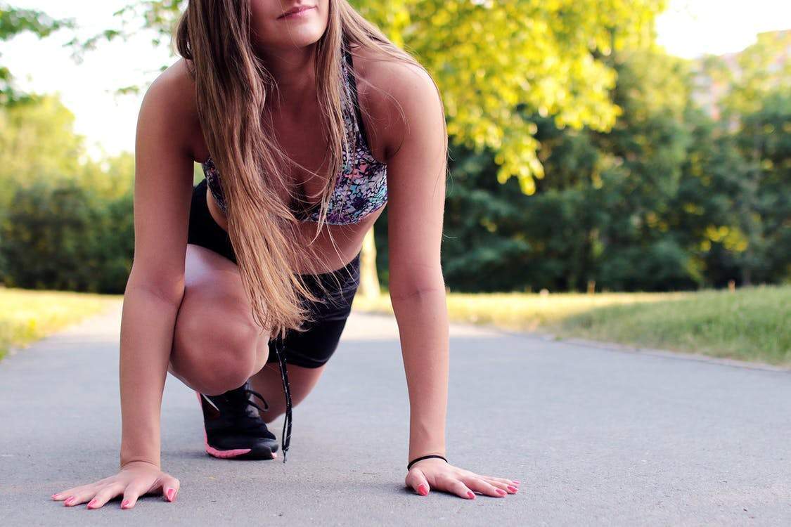 Woman demonstrating exercises for shedding fat in one week, wearing activewear